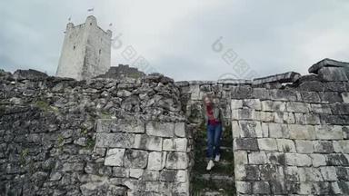 在<strong>一座</strong>高塔的背景下，可爱的女孩正走下<strong>一座</strong>古老堡垒的石阶